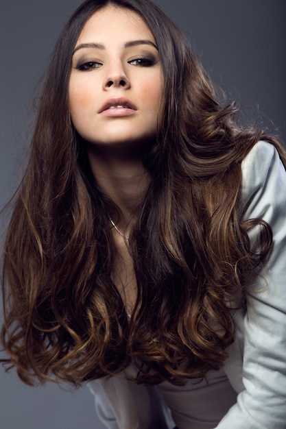 Retrato de la mujer bastante joven que presenta en la foto del estudio.