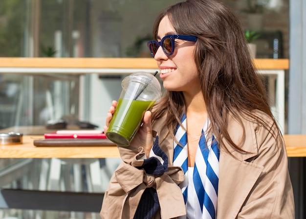 Foto gratuita retrato de mujer bebiendo batido verde