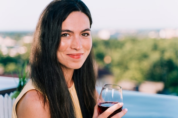Retrato de mujer bebiendo vino en la azotea