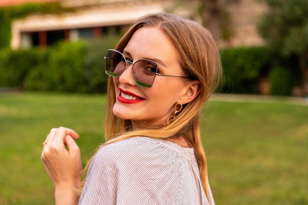 Retrato de mujer de belleza natural de cerca, maquillaje suave, labios rojos, colores cálidos de verano, frescura y felicidad.