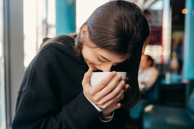 Retrato de mujer bonita bebiendo café de cerca.