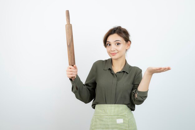 Retrato de mujer bonita en delantal sosteniendo un rodillo. foto de alta calidad