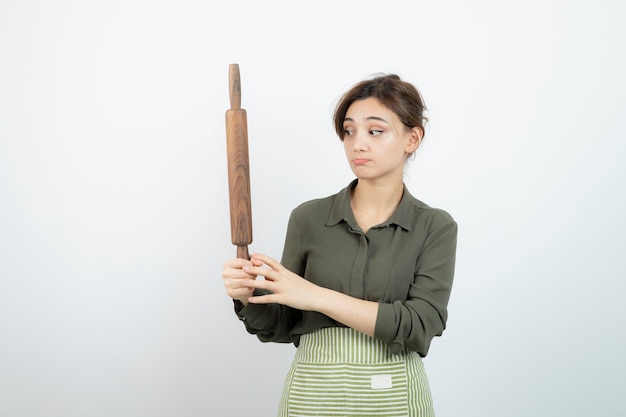 Retrato de mujer bonita en delantal sosteniendo un rodillo. foto de alta calidad