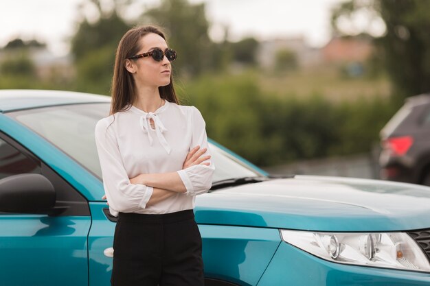 Retrato de mujer bonita delante de un coche