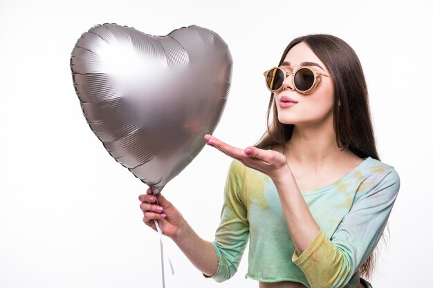 Retrato de mujer bonita envía beso de aire con forma de corazón de globo rojo