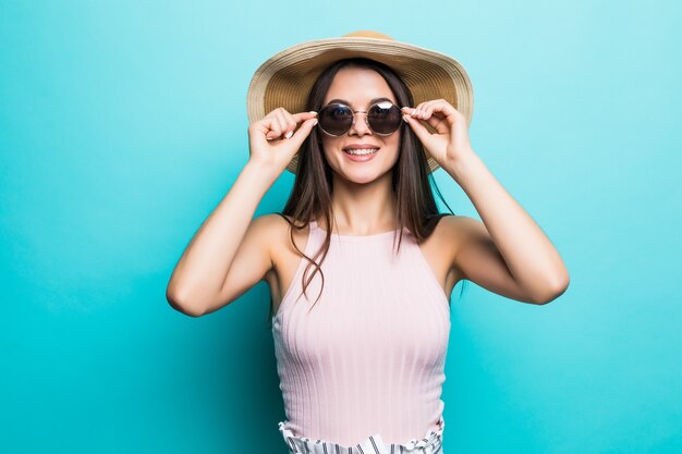 Retrato de mujer bonita en gafas de sol y sombrero sobre azul colorido. Concepto de verano.