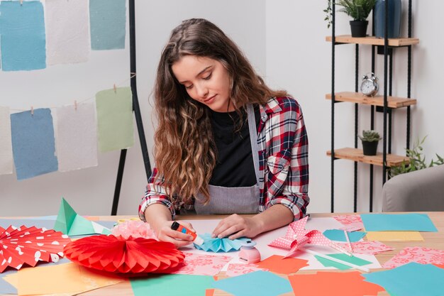 Retrato de mujer bonita haciendo origami creativo trabajo de arte