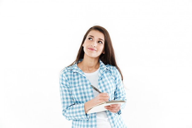 Retrato de una mujer bonita pensativa haciendo notas