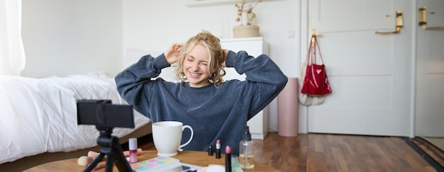 Retrato de una mujer bonita y sonriente, una chica rubia bebiendo té y grabando un video blog de estilo de vida casual