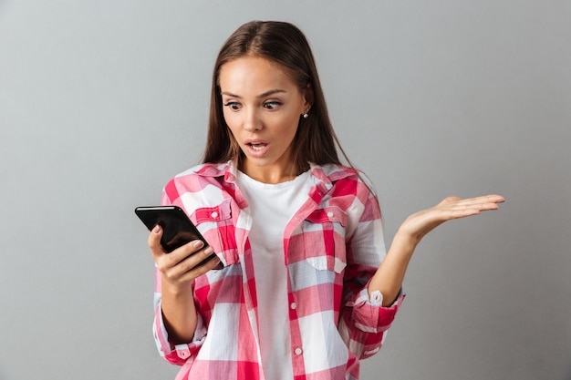 Foto gratuita retrato de una mujer bonita sorprendida en camisa a cuadros