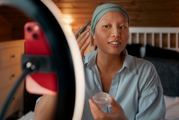 Foto gratuita retrato de una mujer con cáncer haciendo su maquillaje en casa