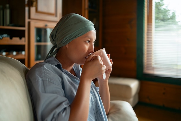 Foto gratuita retrato de una mujer con cáncer tomando una copa en casa