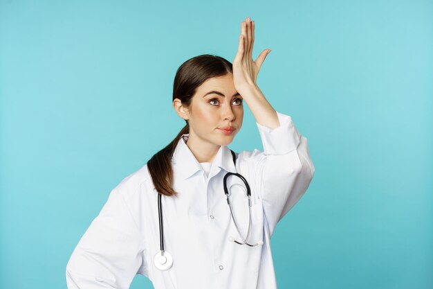 Retrato de mujer cansada molesta doctor facepalm rodar los ojos frustrado molesto por algo estúpido suplente...