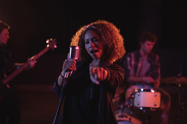 Retrato de mujer cantando en micrófono