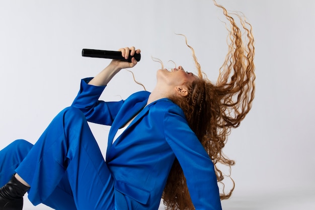 Retrato de mujer cantando pelirroja con micorphone