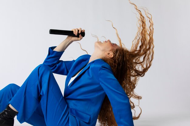 Retrato de mujer cantando pelirroja con micorphone