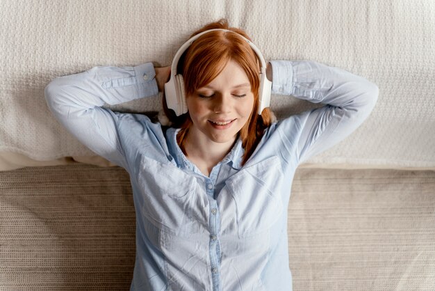 Retrato de mujer en casa escuchando música