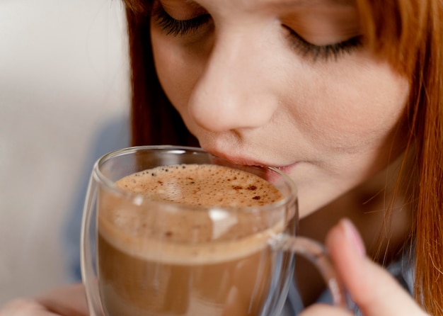 Retrato de mujer en casa tomando café