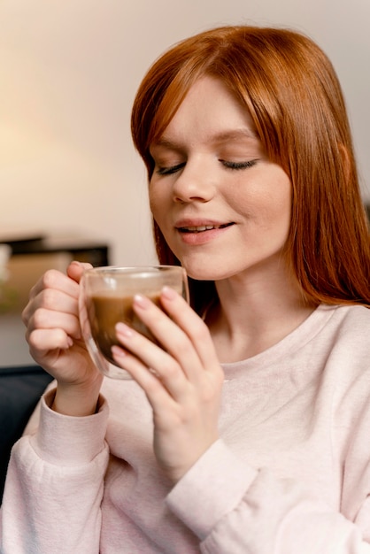 Retrato de mujer en casa tomando café