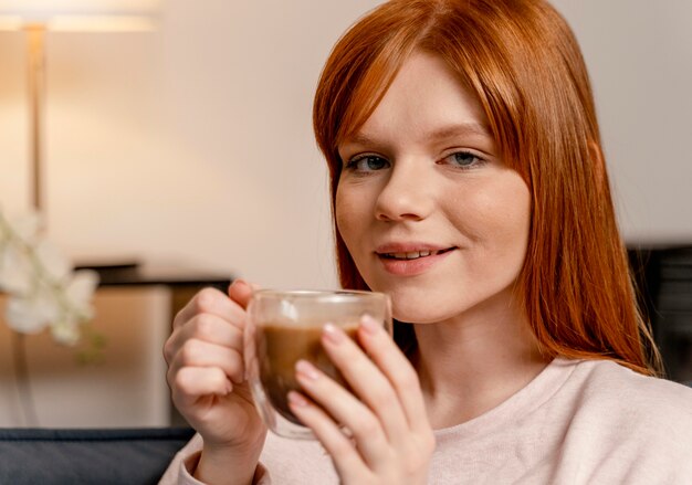 Retrato de mujer en casa tomando café