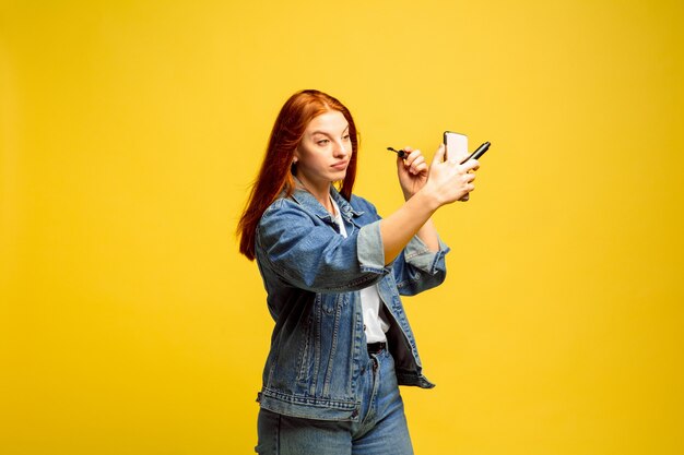 Retrato de mujer caucásica aislado sobre fondo amarillo studio, seguidor sea como