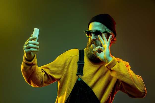 Retrato de mujer caucásica en el espacio degradado en luz de neón. Hermoso modelo masculino con estilo hipster en gafas