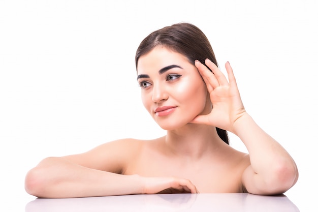 Retrato de la mujer caucásica hermosa joven que toca su cara aislada. Limpieza facial, cuidado de la piel y concepto de cosmetología