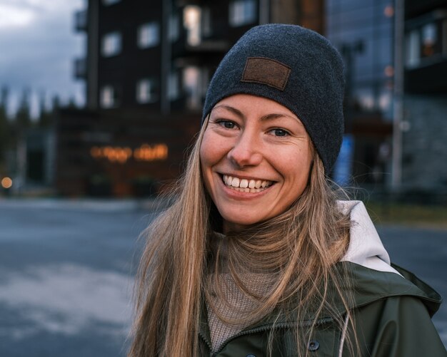 Retrato de una mujer caucásica rubia sonriente en un abrigo y un sombrero en invierno