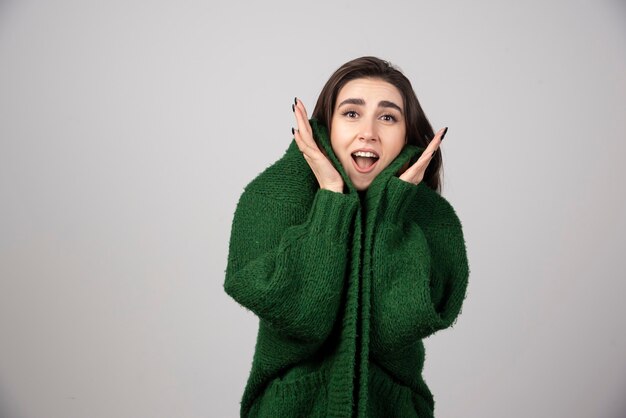 Retrato de mujer con chaqueta verde sintiéndose feliz.