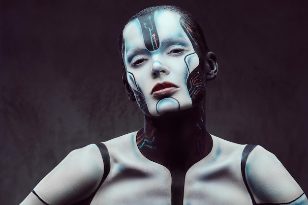 Retrato de una mujer cibernética sensual con maquillaje creativo posando sobre un fondo de textura oscura. Tecnología y concepto de futuro.
