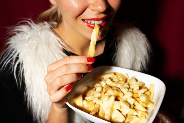 Foto gratuita retrato de mujer comiendo un plato de poutine