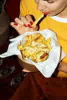 Foto gratuita retrato de mujer comiendo un plato de poutine