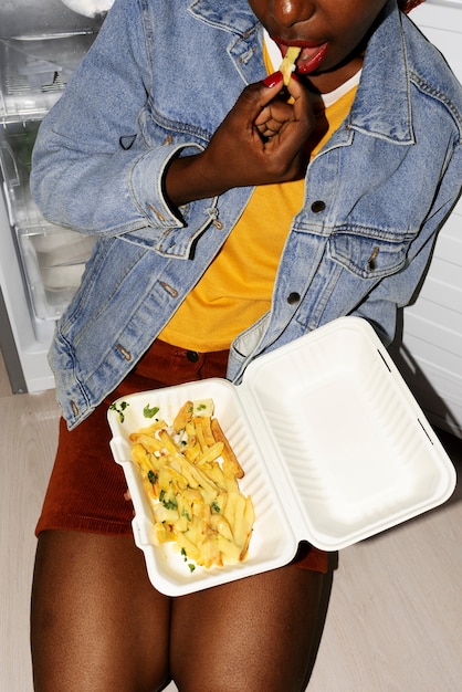 Retrato de mujer comiendo un plato de poutine