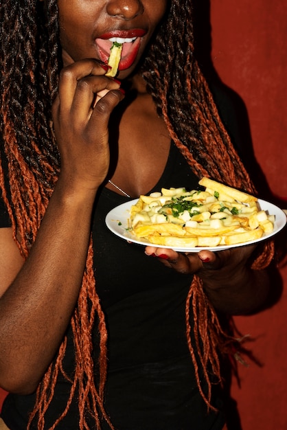 Retrato de mujer comiendo un plato de poutine