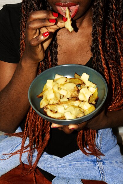 Retrato de mujer comiendo un plato de poutine