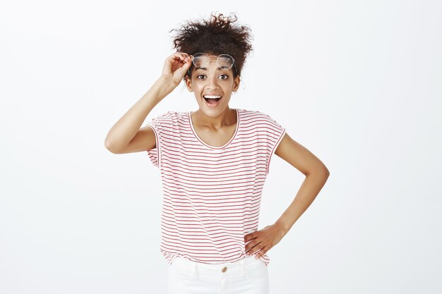 Retrato de mujer complacida con peinado afro posando en el estudio