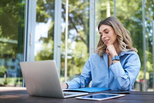 Retrato de mujer corporativa con laptop trabajando en proyecto usando computadora al aire libre joven estudiante doi