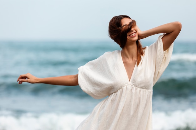 Foto gratuita retrato, de, mujer, cubierta, ella, cara, con, pelo, en la playa