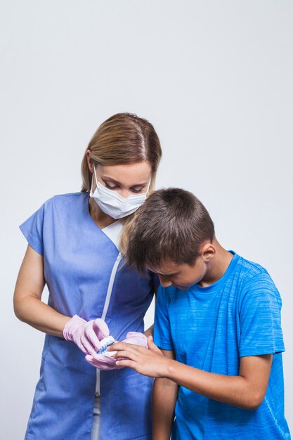 Retrato de mujer dentista y niño mirando dientes modelo