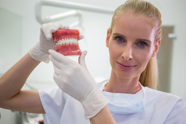 Retrato de mujer dentista sosteniendo un conjunto de prótesis