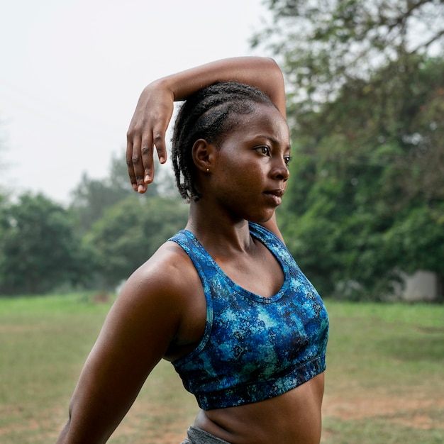 Retrato de mujer deportiva en la naturaleza que se extiende