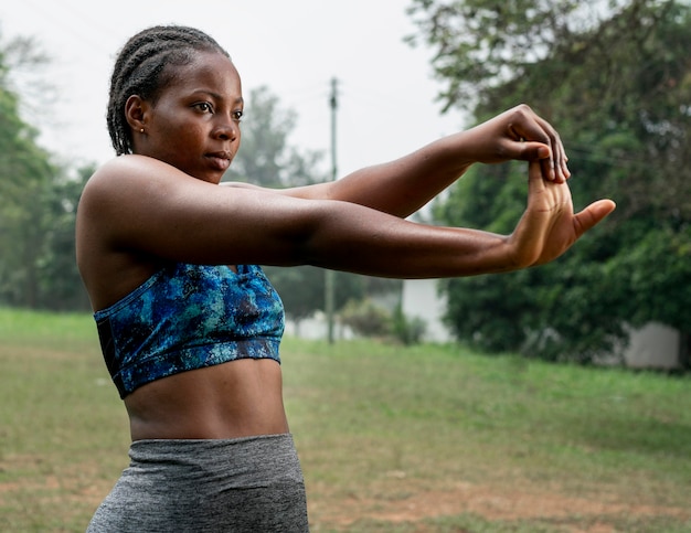 Retrato de mujer deportiva en la naturaleza que se extiende