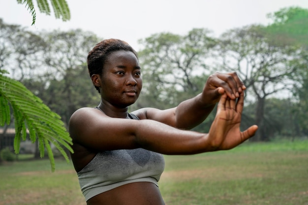 Foto gratuita retrato de mujer deportiva en la naturaleza que se extiende