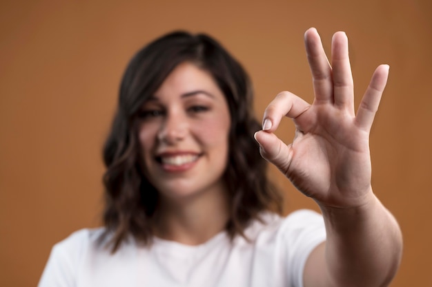 Retrato de mujer desenfocada mostrando signo bien