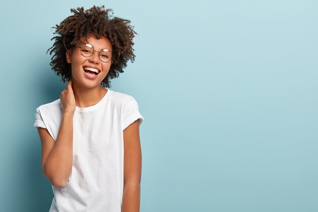 Retrato de mujer despreocupada feliz toca el cuello suavemente, demuestra belleza natural