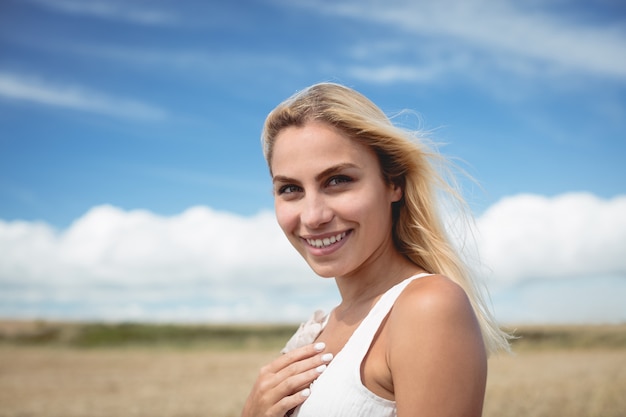 Retrato de mujer despreocupada de pie en el campo