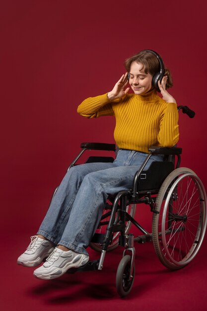 Retrato de mujer discapacitada en silla de ruedas con auriculares