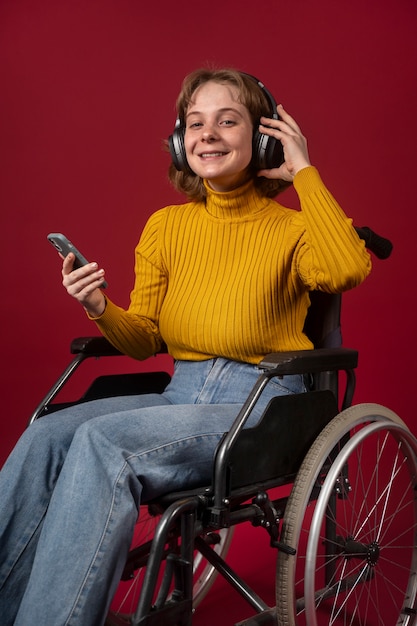 Retrato de mujer discapacitada en silla de ruedas con auriculares