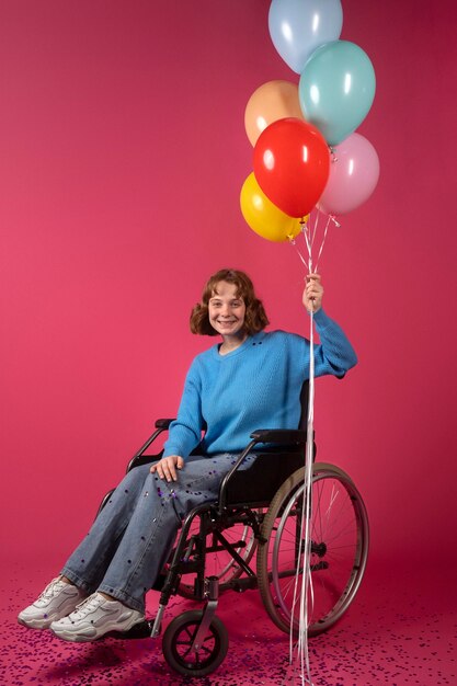 Retrato de mujer discapacitada en silla de ruedas con globos