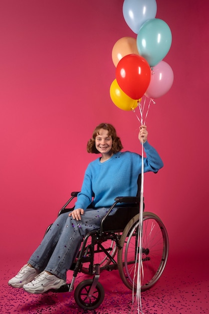 Retrato de mujer discapacitada en silla de ruedas con globos